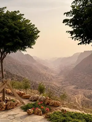 a view of a mountain valley with a tree and flowers at Dana Trail Cottages in Dana