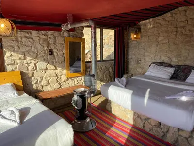a bedroom with two beds and a stone wall at Dana Trail Cottages in Dana