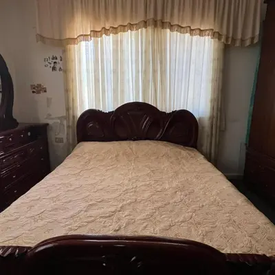 a bedroom with a large bed with a window at Ajloun Rest House in ‘Ayn Jannā