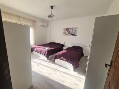 two beds in a room with a door open at Khalda Rooftop Apt. in Amman