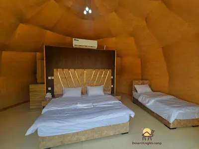 a bedroom with two beds in a large room at Desert Knights camp in Wadi Rum