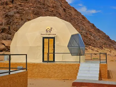 a dome building with stairs in front of a mountain at Desert Knights camp in Wadi Rum