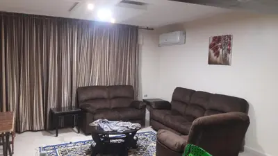 a living room with two chairs and a couch and a table at Mesha Stele Private Hotel in Madaba