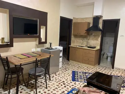 a kitchen with a table and chairs in a room at Mesha Stele Private Hotel in Madaba