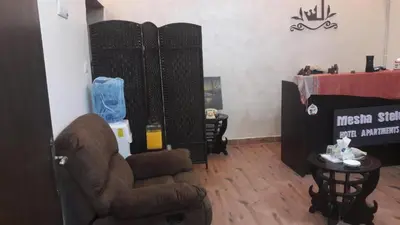 a living room with a chair and a table at Mesha Stele Private Hotel in Madaba