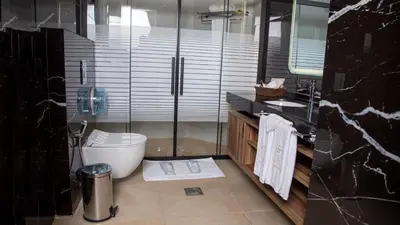 a bathroom with a toilet and a glass shower at Jeddah Homes Boutique Hotel in Amman