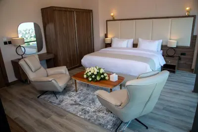 a hotel room with a bed and two chairs and a table at Jeddah Homes Boutique Hotel in Amman