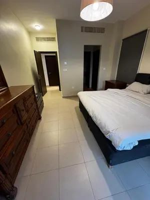a bedroom with a large bed with a wooden dresser at Apartment at Samarah Dead Sea Resort APT D-09 in Sowayma