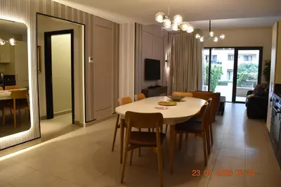 a dining room and living room with a table and chairs at Apartment at Samarah Dead Sea Resort APT D-09 in Sowayma