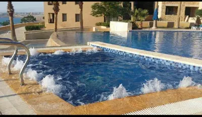 a swimming pool with a fountain in the middle at Apartment at Samarah Dead Sea Resort APT D-09 in Sowayma