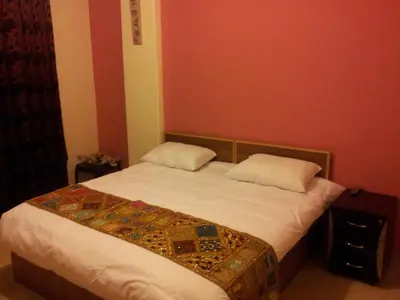 a bedroom with a bed with two pillows on it at Jordan River Hotel in Amman