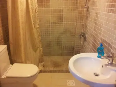 a bathroom with a toilet and a sink and a shower at Jordan River Hotel in Amman