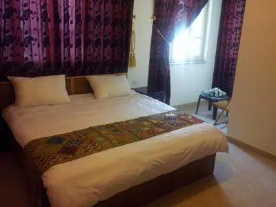 a bedroom with a large bed with a window at Jordan River Hotel in Amman