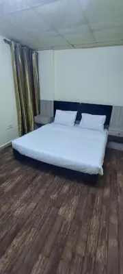 a large bed in a room with a wooden floor at Venice in Aqaba