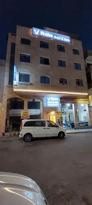 a limo parked in front of a building at night at Venice in Aqaba