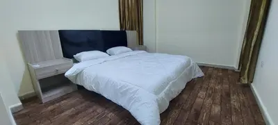 a bedroom with a white bed and two windows at Venice in Aqaba