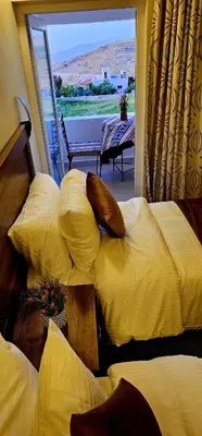 a hotel room with two beds and a balcony at Petra Passion Inn in Taiyiba