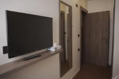 a flat screen tv on a wall in a hotel room at Petra Passion Inn in Taiyiba