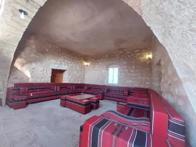 a large room with red benches in a stone wall at Tafileh-Sila'a Heritage Village in At-Tafilah