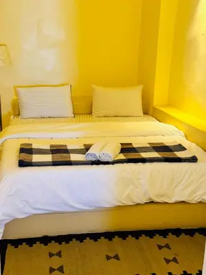 a bed with two pillows and towels on it at Tafileh-Sila'a Heritage Village in At-Tafilah