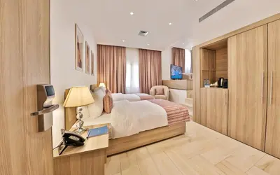 a bedroom with a bed and a desk with a telephone at Lavanda Boutique Suites Tala Bay in Aqaba