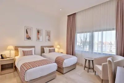 a hotel room with two beds and a window at Lavanda Boutique Suites Tala Bay in Aqaba