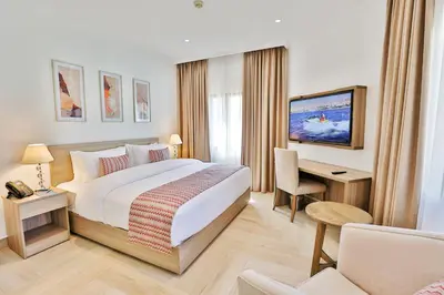 a hotel room with a large bed and a desk at Lavanda Boutique Suites Tala Bay in Aqaba