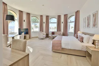 a bedroom with a large bed and a living room at Lavanda Boutique Suites Tala Bay in Aqaba