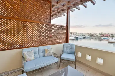 a balcony with two chairs and a view of the water at Lavanda Boutique Suites Tala Bay in Aqaba