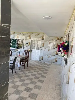a dining room with a table and a stone wall at huseein rooms in Jerash