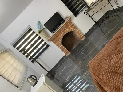 a living room with a brick fireplace and a television at huseein rooms in Jerash