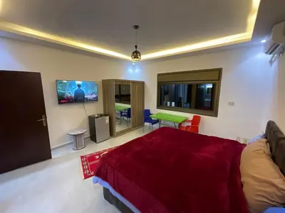 a bedroom with a bed and a flat screen tv at Black IRIS in Jerash