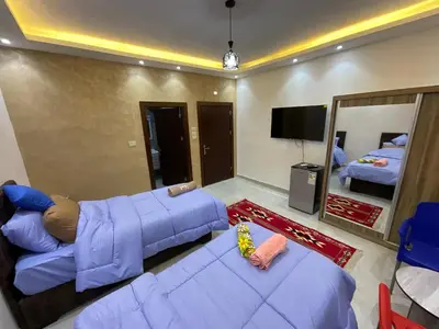 a living room with a blue couch and a mirror at Black IRIS in Jerash
