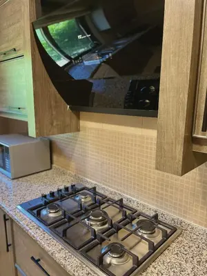 a stove top in a kitchen with a microwave at Fragrant Rose in Wadi Musa