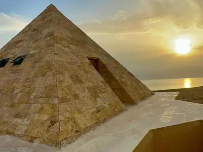 a pyramid building with a sunset in the background at Deadsea OCTAGON in Madaba