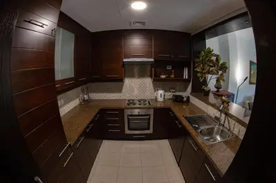 a small kitchen with wooden cabinets and a sink at Sunset apartment in Samarah Dead Sea resort in Sowayma
