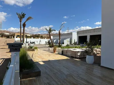 a patio with palm trees and a building at AQABA PRO DIVERS in Aqaba