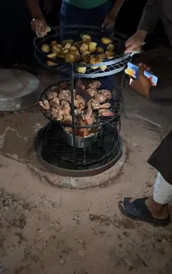 a group of people cooking food on a grill at Wadi Rum Best Tours in Wadi Rum