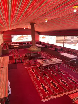 a large room with red carpet and red tables and chairs at Wadi Rum Best Tours in Wadi Rum