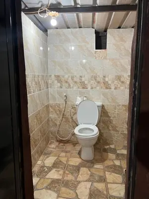a bathroom with a toilet in a tiled room at Wadi Rum Best Tours in Wadi Rum