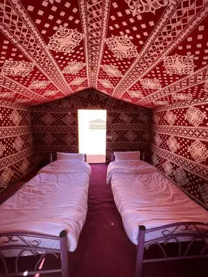 two beds in a room with a red ceiling at Wadi Rum Best Tours in Wadi Rum