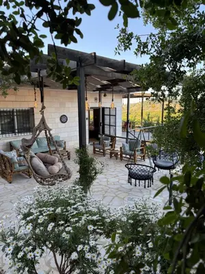 a patio with a hammock and benches in a yard at Oak Farm Ajloun مزرعة البلوط عجلون in Ajloun