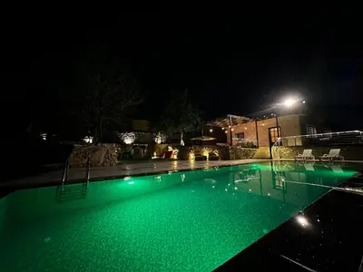 a swimming pool at night with green lights at Oak Farm Ajloun مزرعة البلوط عجلون in Ajloun