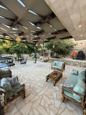 a patio with couches and benches on a stone floor at Oak Farm Ajloun مزرعة البلوط عجلون in Ajloun