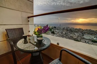 a table on a balcony with a view of a city at De-Lara hotel in Aqaba