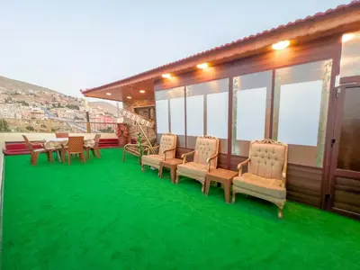 a row of chairs and tables on a green carpet at PETRA ROYAL HOUSE in Wadi Musa