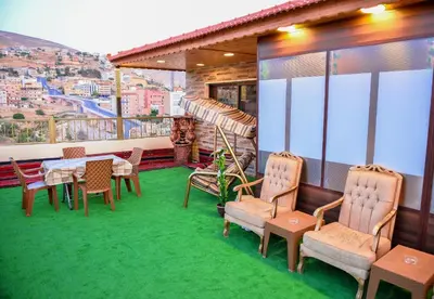 a balcony with a table and chairs and a view at PETRA ROYAL HOUSE in Wadi Musa