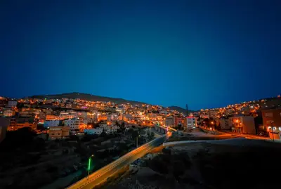a view of a city at night with lights at PETRA ROYAL HOUSE in Wadi Musa