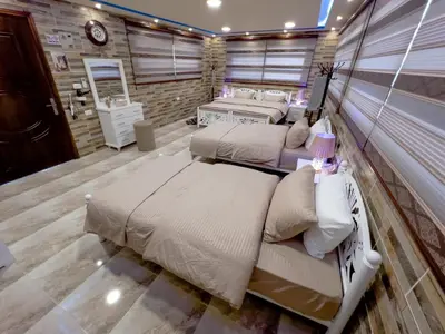 two beds in a room with a wall at PETRA ROYAL HOUSE in Wadi Musa