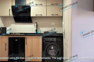 a kitchen with a washing machine in a room at fancy apartment gardens st 410 in Umm Uthainah